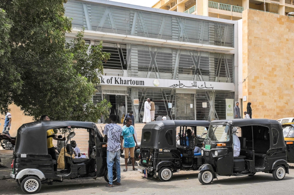 Tuk-tuks (motorised rickshaws) wait for passengers outside a branch of the Bank of Khartoum in Port Sudan on May 23, 2023. (Photo by AFP)
