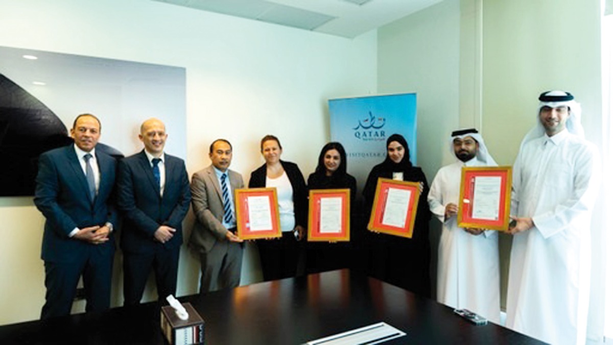 Qatar Tourism officials with ISO certifications.