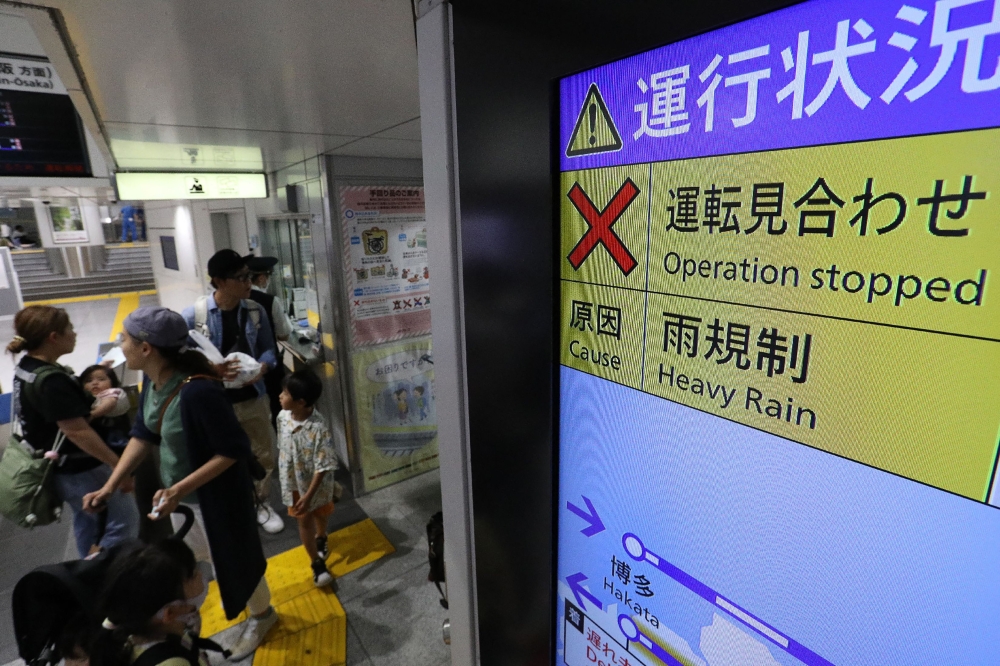 A monitor reports the suspension of operation of the Tokaido Shinkansen, or bullet trains services the route between Tokyo and Osaka, at Tokyo Station on June 2, 2023, after service was stopped due to heavy rains caused by passing Tropical Storm Mawar. (Photo by JIJI Press / AFP)