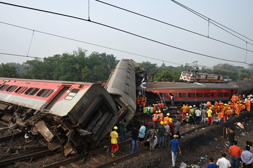 Rescue workers gather around damaged carriages during search for survivors at the accident site of a three-train collision near Balasore, about 200 km (125 miles) from the state capital Bhubaneswar in the eastern state of Odisha, on June 3, 2023. (Photo by Dibyangshu Sarkar / AFP)

