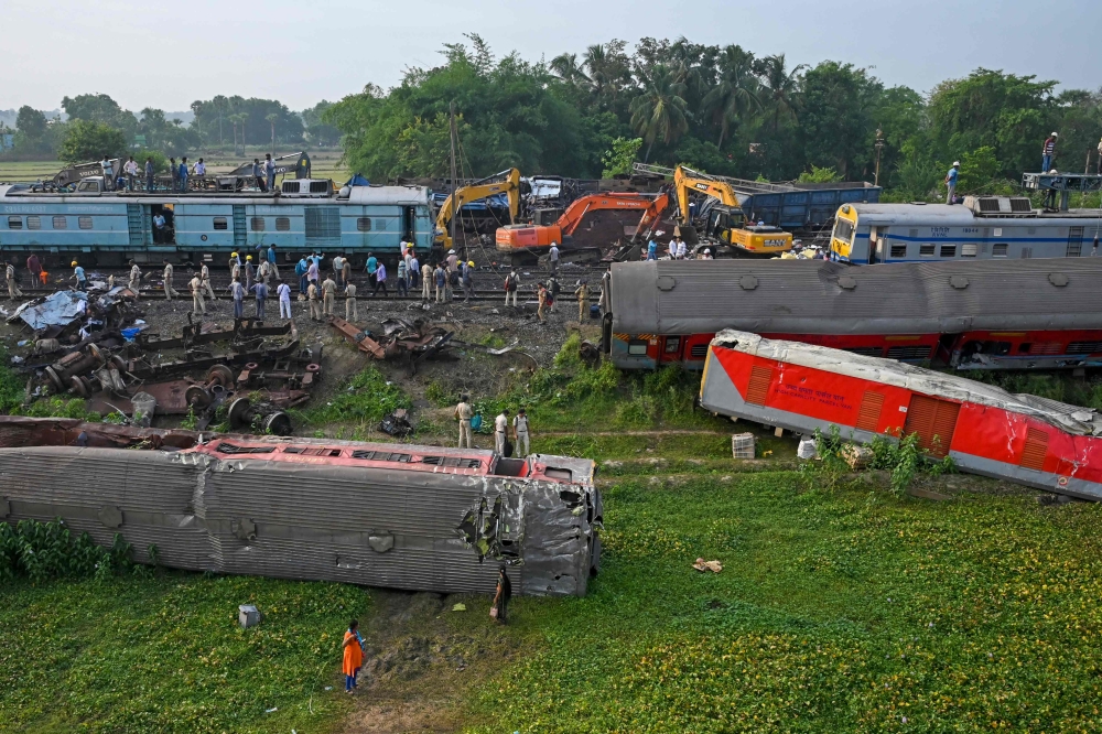 Policemen inspect the wrecked carriages of a three-train collision near Balasore, in India's eastern state of Odisha, on June 4, 2023. (Photo by Dibyangshu Sarkar / AFP)