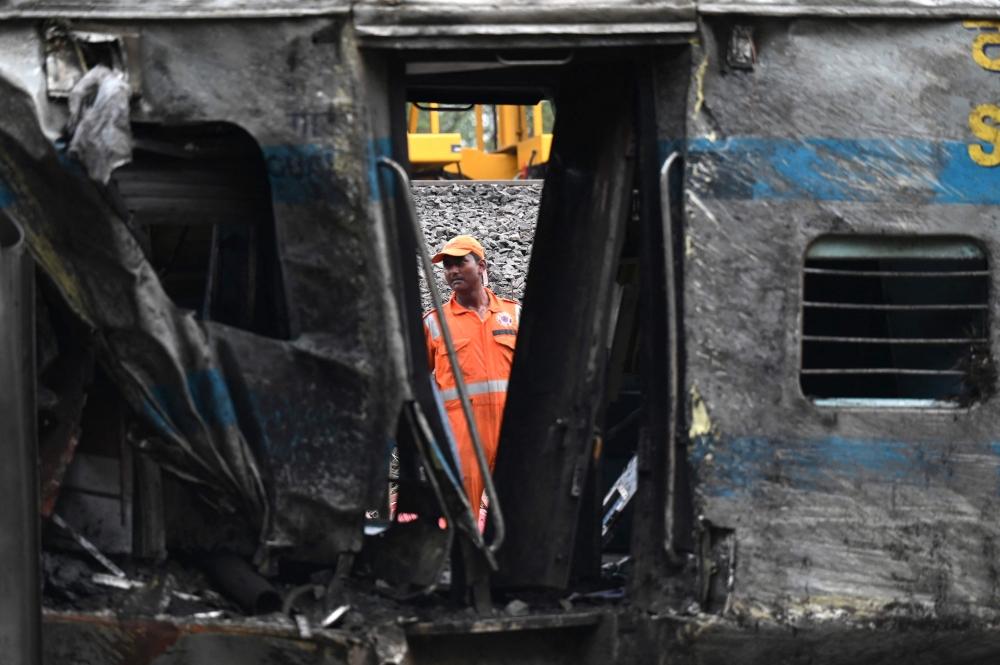 A rescue worker inspects a damaged carriage at the accident site of a three-train collision near Balasore, about 200 km (125 miles) from the state capital Bhubaneswar in the eastern state of Odisha, on June 4, 2023. Photo by Punit PARANJPE / AFP
