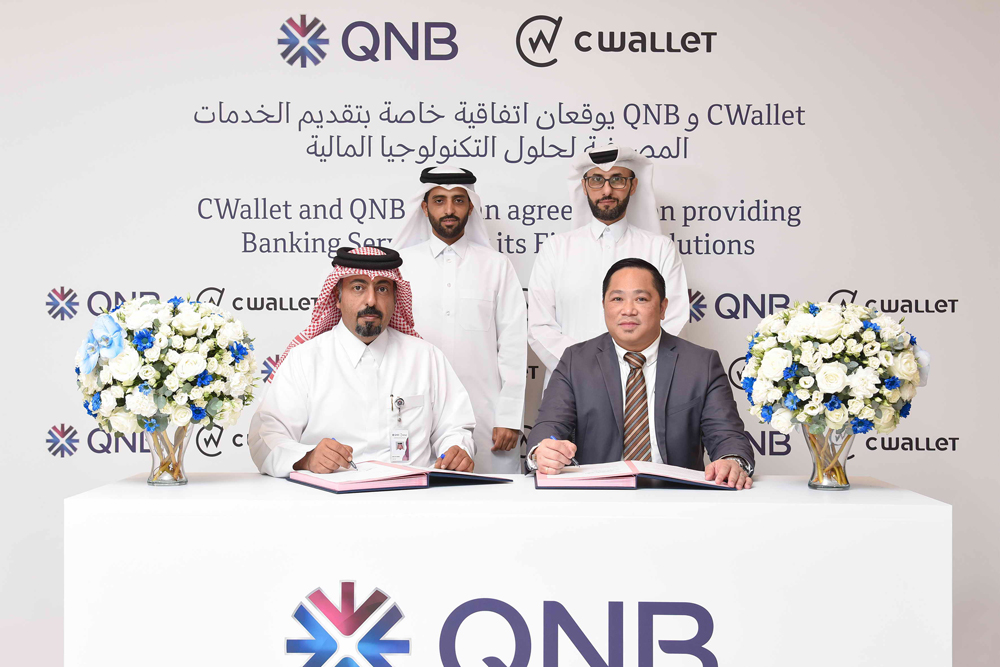 Officials of QNB and CWallet during the signing ceremony.