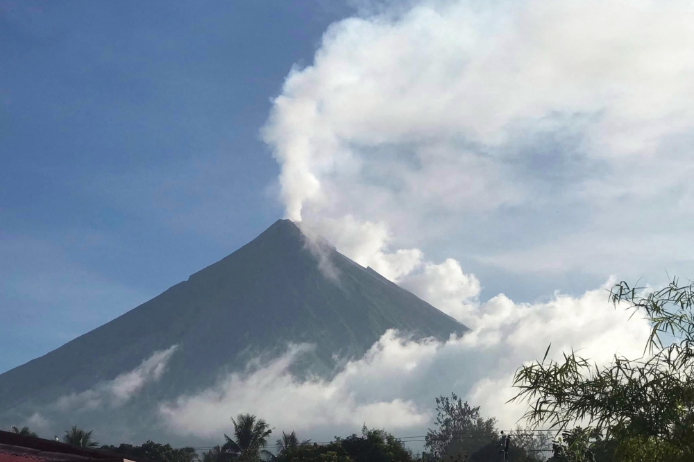 This handout photo made available by Kristin Moral shows the Mount Mayon spewing white smoke as seen from Camalig, Albay, in the Philippines, on June 8, 2023. (Photo by Handout / AFP) 