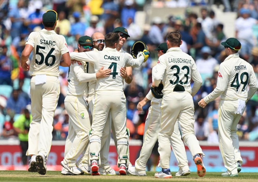 Australia's Nathan Lyon (C) celebrates with teammates Australia's Travis Head (2L) and Australia's Pat Cummins (C/R) and others after the dismissal of India's Mohammed Shami at The Oval, in London, on June 11, 2023. (Photo by Glyn KIRK / AFP)