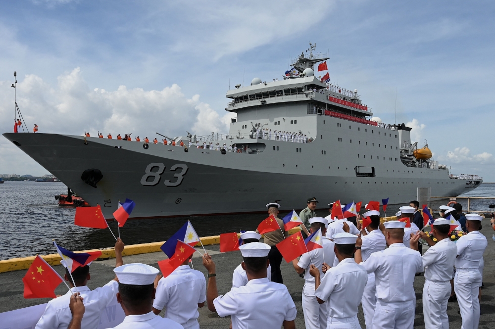 Philippine Navy personnel wave flags as they welcome the arrival of the Chinese naval training ship “Qi Jiguang” in Manila on June 14, 2023. (Photo by Jam Sta Rosa / AFP)