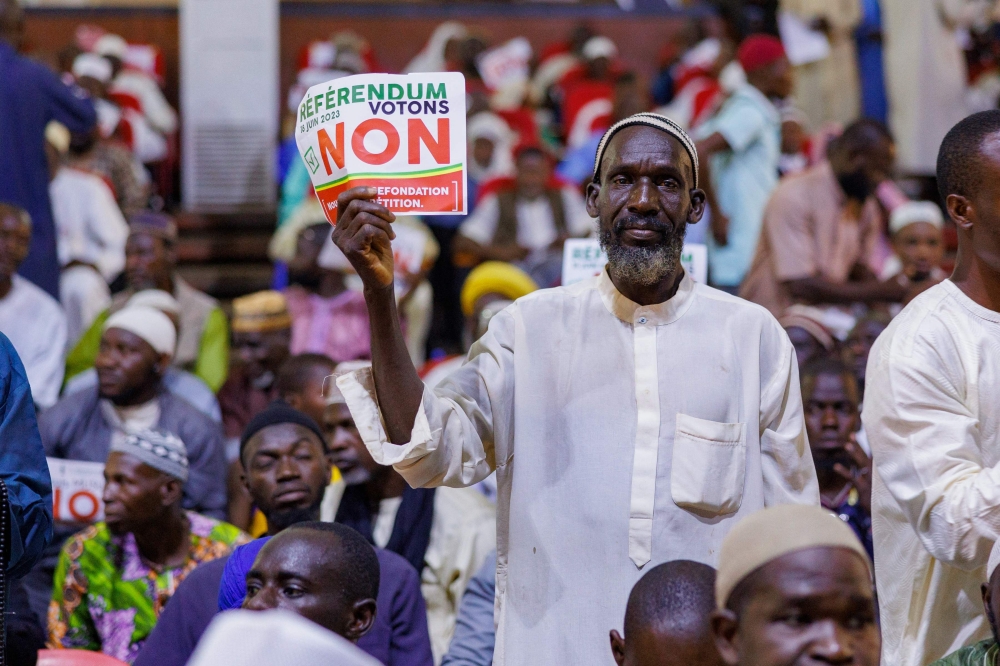 A man holds up a sign that reads 