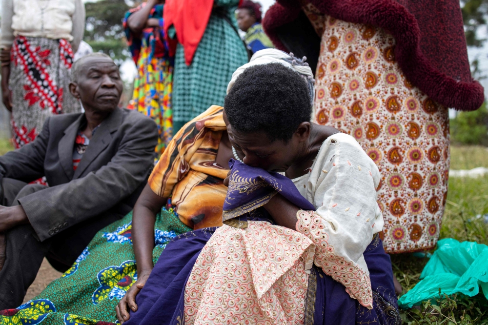 Relatives of victims of the Mpondwe Lhubiriha Secondary School mourn outside the Bwera General Hospital Mortuary, Kasese, on June 18, 2023. (Photo by Stuart Tibaweswa / AFP)