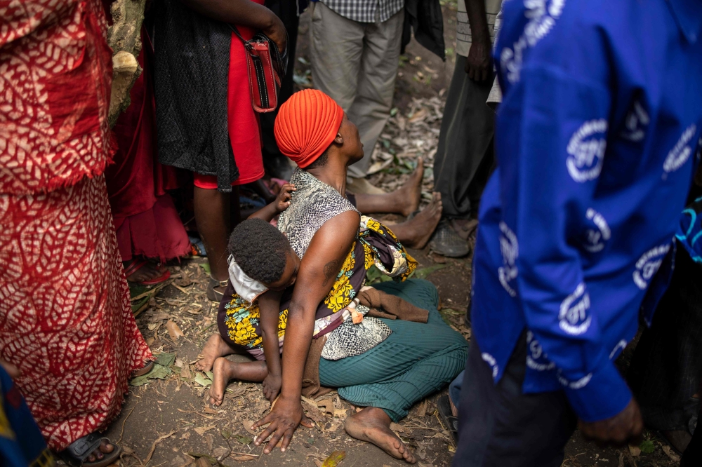 A woman mourns during the funeral of Florence Masika and Zakayo Masereka in Mpondwe in western Uganda, on June 18, 2023. (Photo by Stuart Tibaweswa / AFP)
