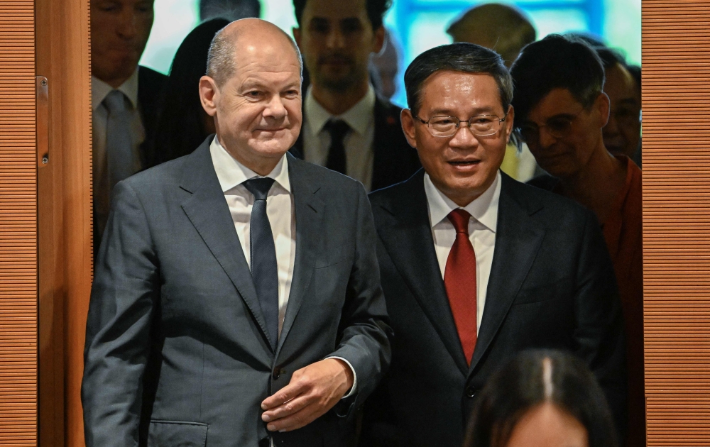 German Chancellor Olaf Scholz (L) and China's Premier Li Qiang enter the conference room to attend German-Chinese economy consultations on June 20, 2023 at the Chancellery in Berlin.
Photo by Tobias SCHWARZ / AFP
