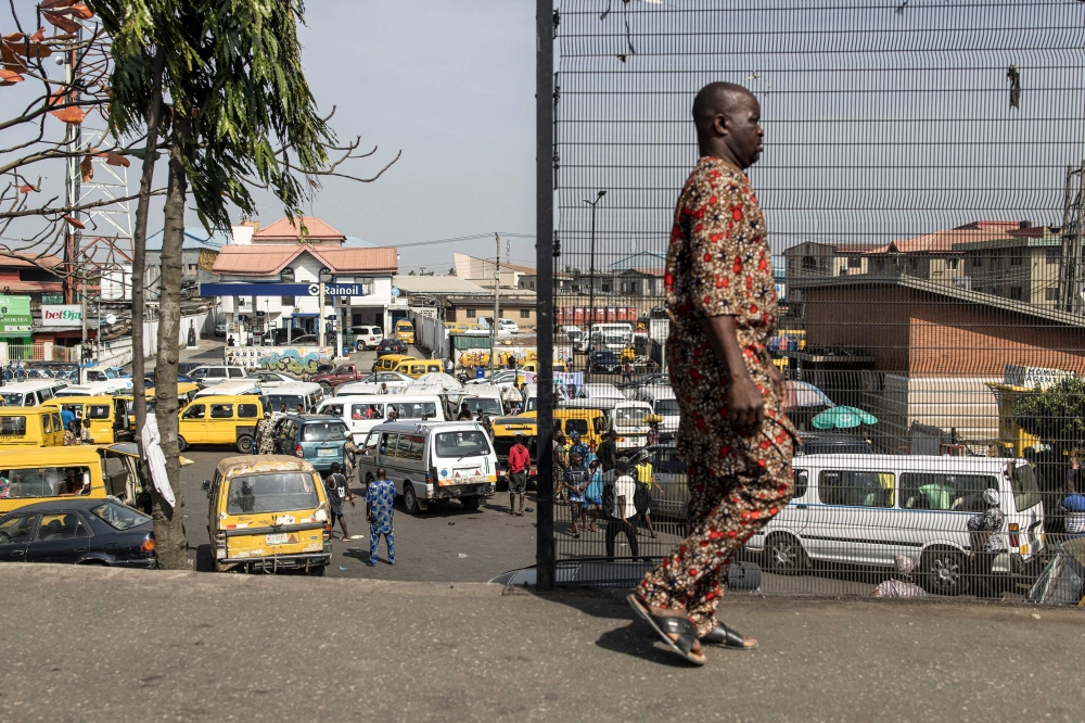 File photo: A man walks past a taxi stop in Lagos on February 28, 2023. (Photo by JOHN WESSELS / AFP)

