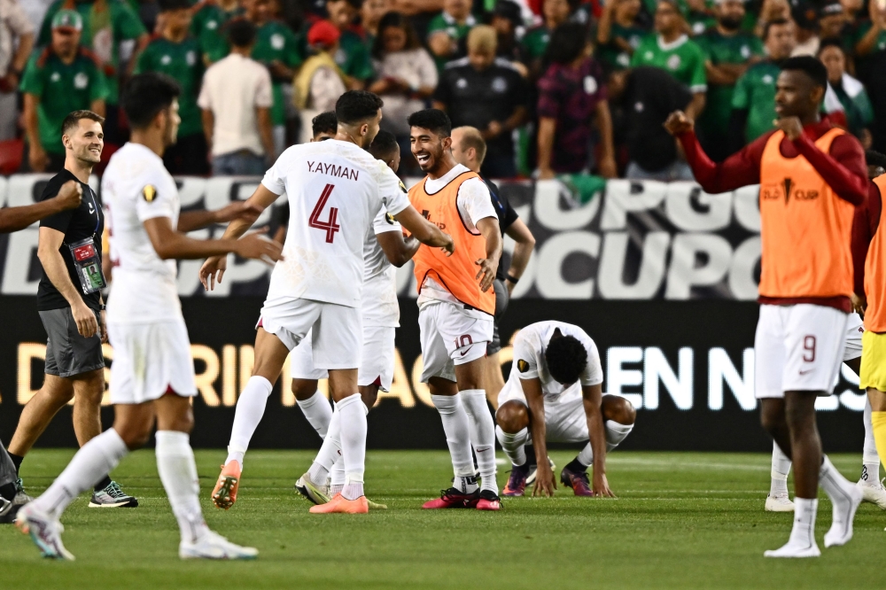Qatar's players celebrate their victory following the Concacaf 2023 Gold Cup Group B football match between Mexico and Qatar at Levi's Stadium, in Santa Clara, California, on July 2, 2023. (Photo by Patrick T. Fallon / AFP)
