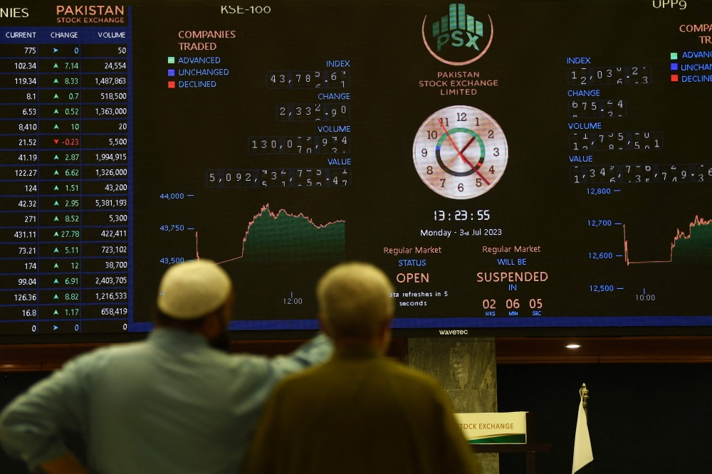 Stockbrokers monitor the latest share prices at the Pakistan Stock Exchange (PSE) in Karachi on July 3, 2023. (Photo by Asif Hassan / AFP)
