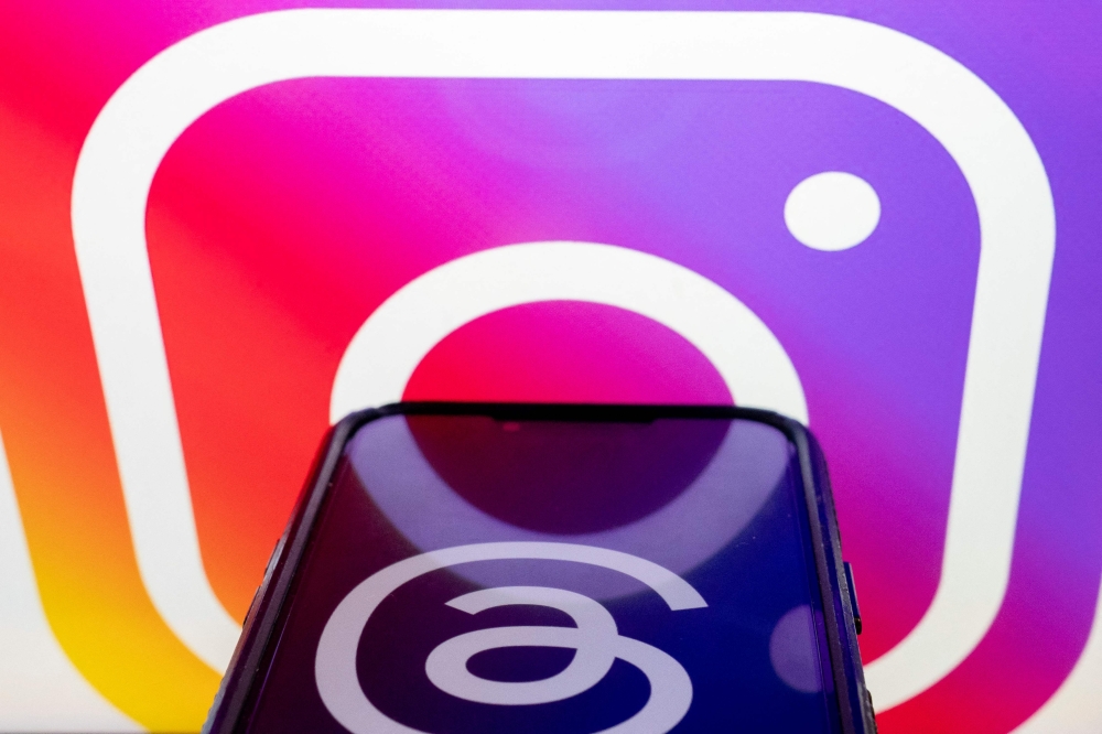 This photo illustration created in Washington, DC, on July 5, 2023, shows the logos for Threads, an Instagram app, and Instagram. Facebook owner Meta's new Threads app, meant to compete with Twitter, was available for pre-order on mobile app stores on iPhone and Android operating systems on July 5, 2023. (Photo by Stefani Reynolds / AFP)
