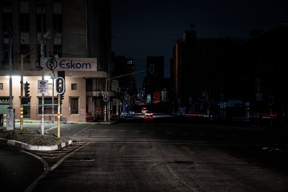 File Photo: An illuminated signboard on display outside the Eskom Regional Office in Braamfontein, Johannesburg during load-shedding (rolling blackout) on 31 January, 2023. (AFP)