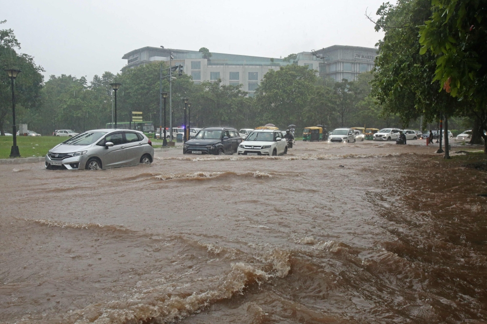 Vehicles make their way through a waterlogged road during heavy rainfall in Chandigarh on July 10, 2023. (Photo by AFP)