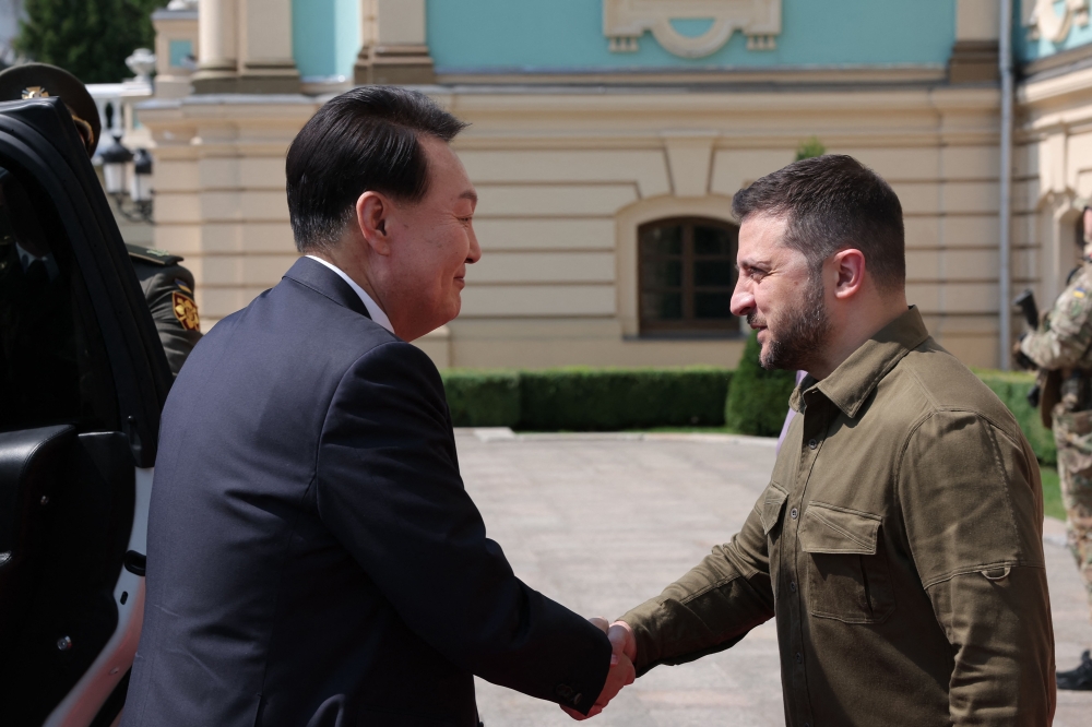 This handout photo taken on July 15, 2023 and released by the South Korean Presidential Office via Yonhap shows South Korean President Yoon Suk Yeol (left) shaking hands with Ukrainian President Volodymyr Zelensky during their meeting at the presidential palace in the Ukrainian capital Kyiv. (Photo by Handout / South Korean Presidential Office / AFP)