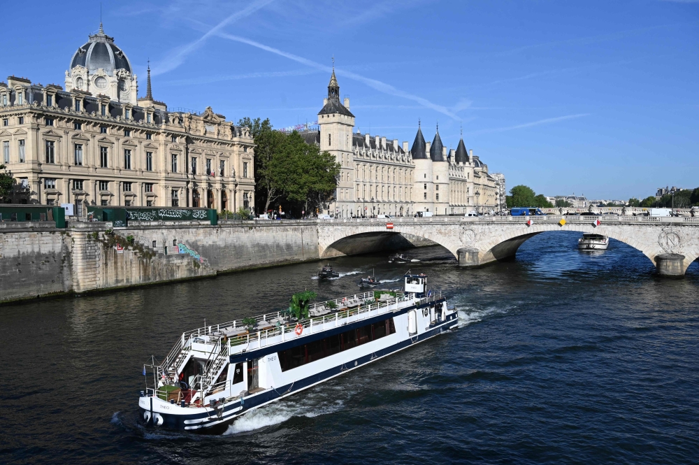 A Peniche boat sails past the Quai de l'Horloge during a parade on the River Seine in Paris on July 17, 2023, to test 