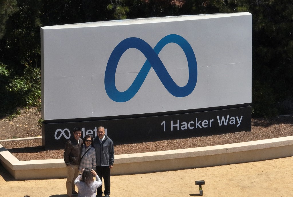 In an aerial view, people gather in front of a sign posted at Meta headquarters on July 07, 2023 in Menlo Park, California. Photo by JUSTIN SULLIVAN / GETTY IMAGES NORTH AMERICA / Getty Images via AFP