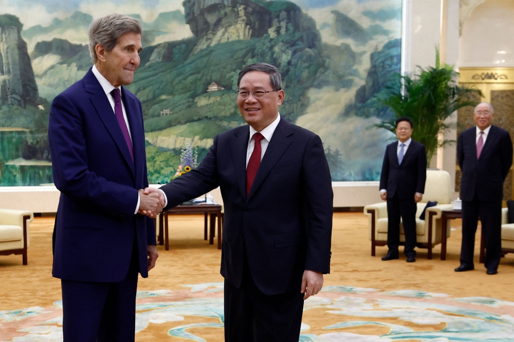 US Climate Envoy John Kerry (L) and China's Premier Li Qiang shake hands before a meeting at the Great Hall of the People in Beijing on July 18, 2023. (Photo by Florence Lo / Pool / AFP)