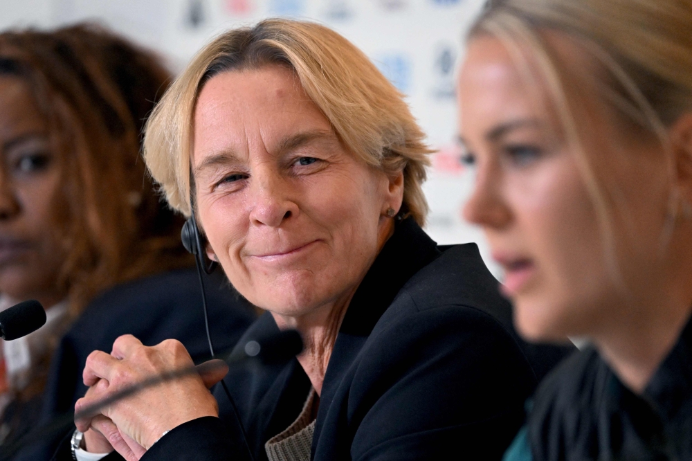 Germany's coach Martina Voss-Tecklenburg (L) listens to player Merle Frohms (R) speak during a press conference in Melbourne on July 23, 2023, on the eve of the Women's World Cup football match between Germany and Morocco. Photo by William WEST / AFP