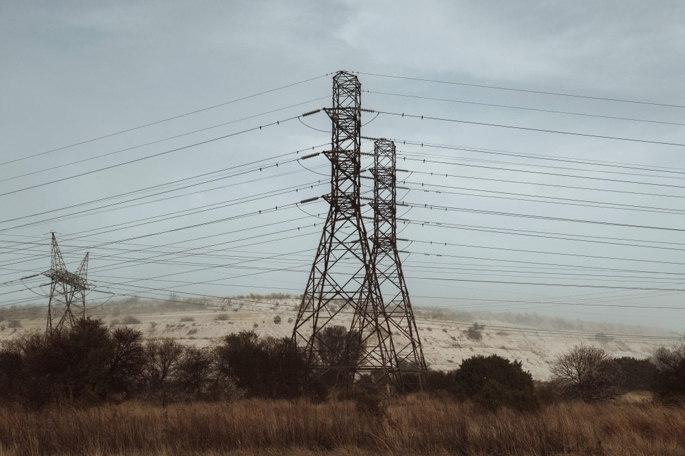 Electric power lines are seen in Stilfontein, on July 23, 2023. (Photo by MARCO LONGARI / AFP)
