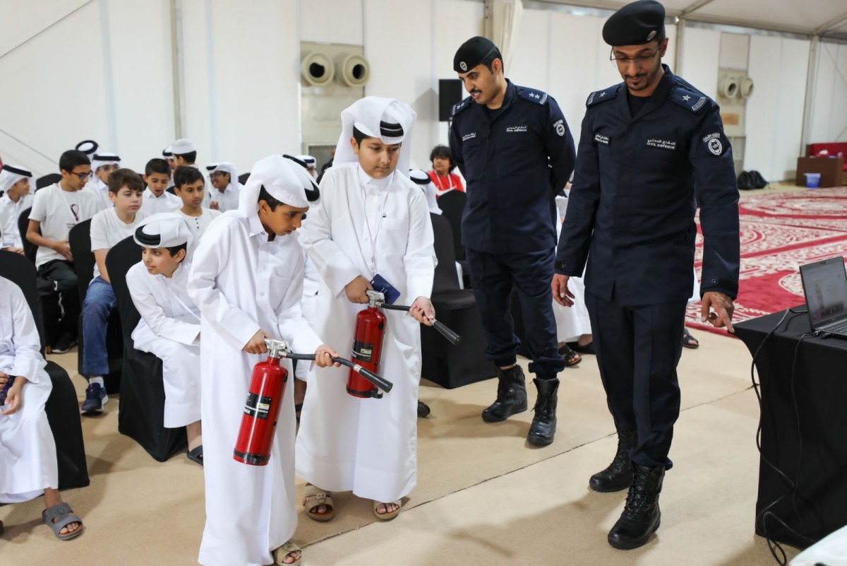 Children being trained on how to use a fire extinguisher.