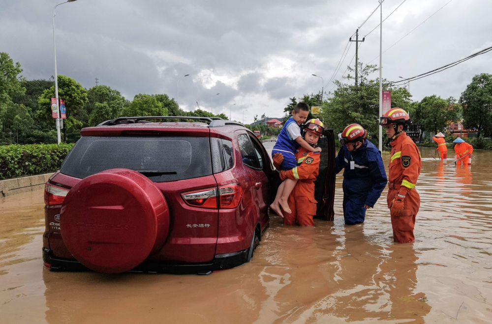 Rescuers evacuate residents in a flooded area after Typhoon Doksuri landfall in Quanzhou, in China's eastern Fujian province on July 28, 2023. (Photo by CNS / AFP) 