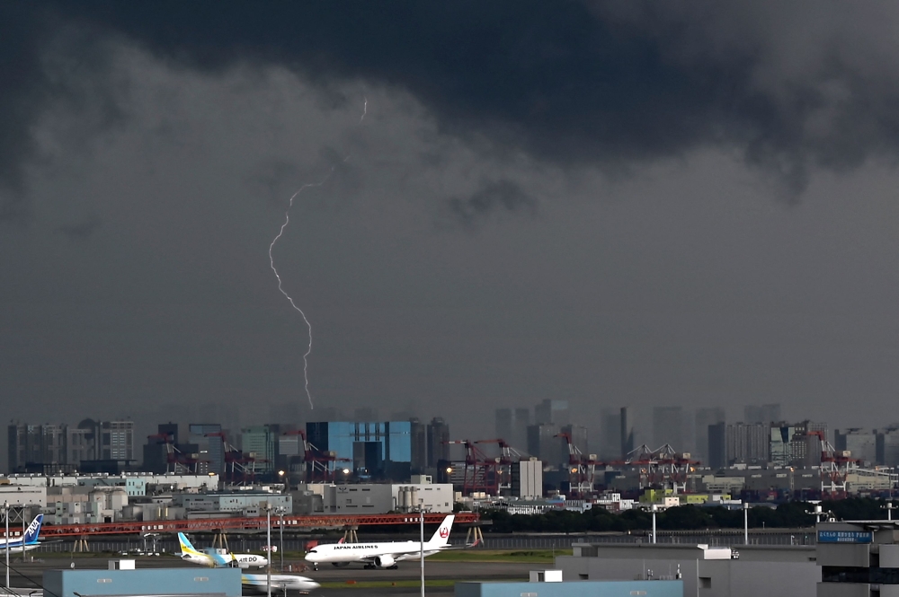 Lightning strikes a building near Tokyo's Haneda Airport (bottom) on August 1, 2023. Photo by Kazuhiro NOGI / AFP