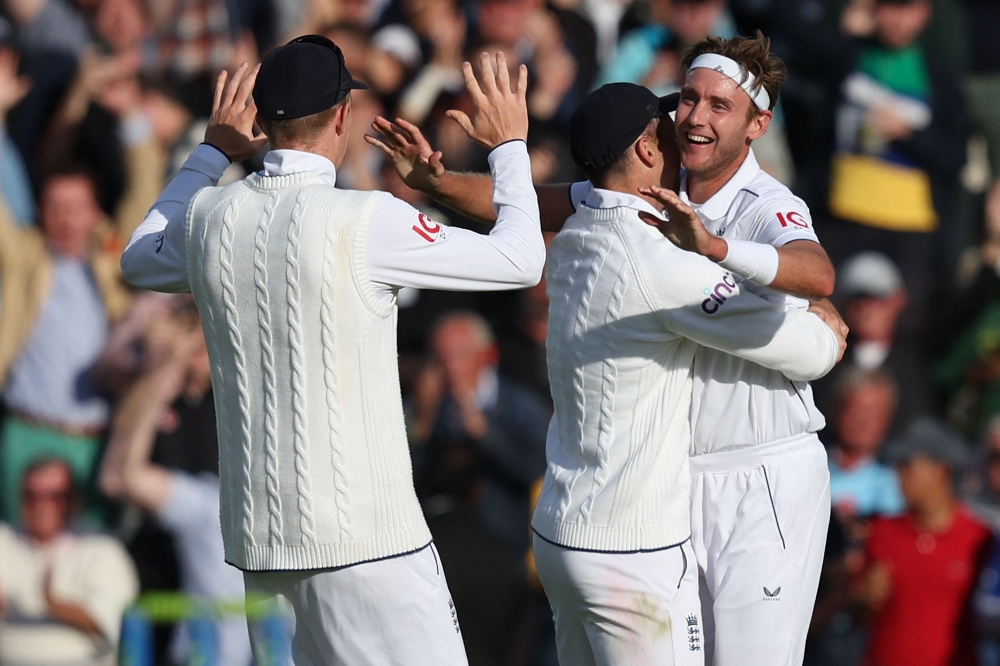 England's Stuart Broad (R) celebrates with England's James Anderson (C) and England's Zak Crawley (L) after England's victory on day five of the fifth Ashes cricket Test match between England and Australia at The Oval cricket ground in London on July 31, 2023. (Photo by Adrian DENNIS / AFP)