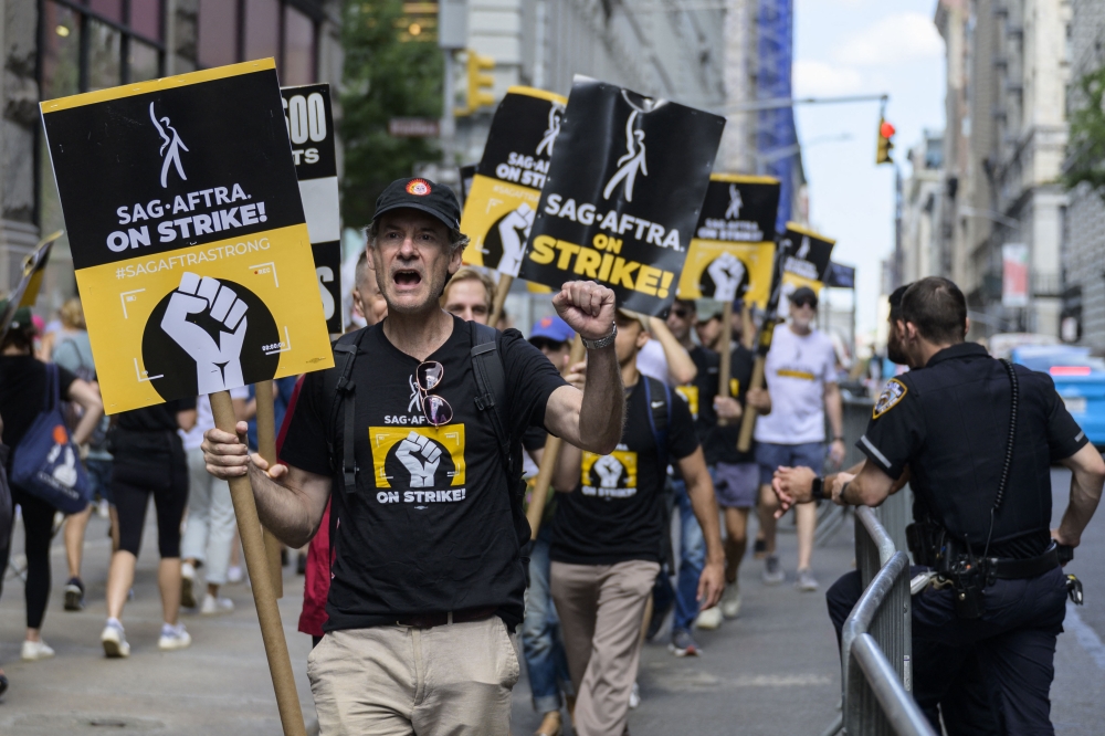 Members of the Writers Guild of America and the Screen Actors Guild walk a picket line outside of Netflix and Warner Bros. Discovery in New York City on August 2, 2023. Photo by ANGELA WEISS / AFP