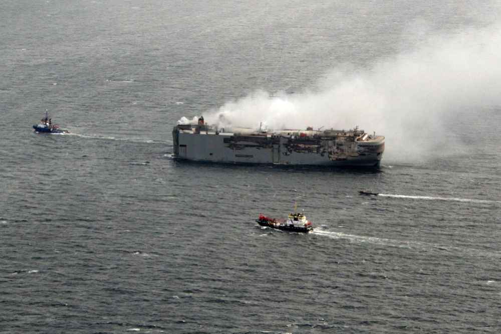 This handout photograph taken on July 29, 2023 and released on July 30, 2023 by the Dutch coastguards, shows smoke rising from the Panamanian-registered car carrier ship Fremantle Highway. Photo by Handout / Netherlands Coastguards / AFP