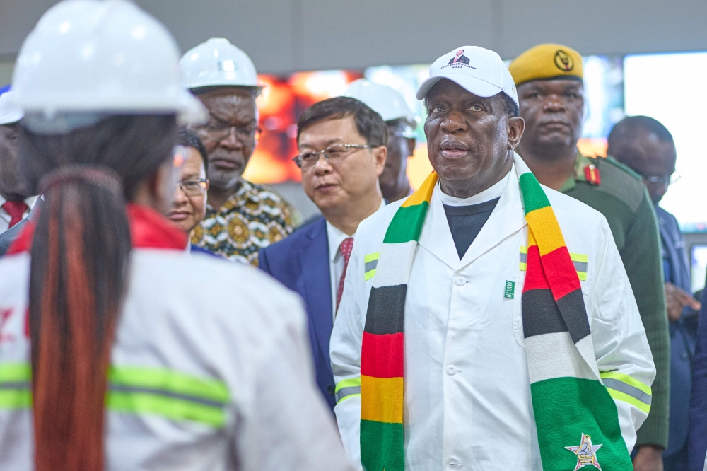 President Emmerson Mnangagwa listens to nn engineer as she explains the systems of a recently upgraded coal powered electricity generator on August 03, 2023, (Photo by Zinyange Auntony / AFP)
