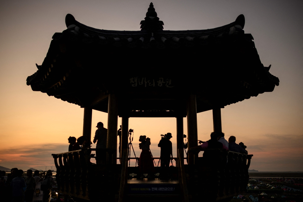 People take photos from a viewing deck overlooking the campsite of the World Scout Jamboree in Buan, North Jeolla province on August 5, 2023. Photo by ANTHONY WALLACE / AFP
