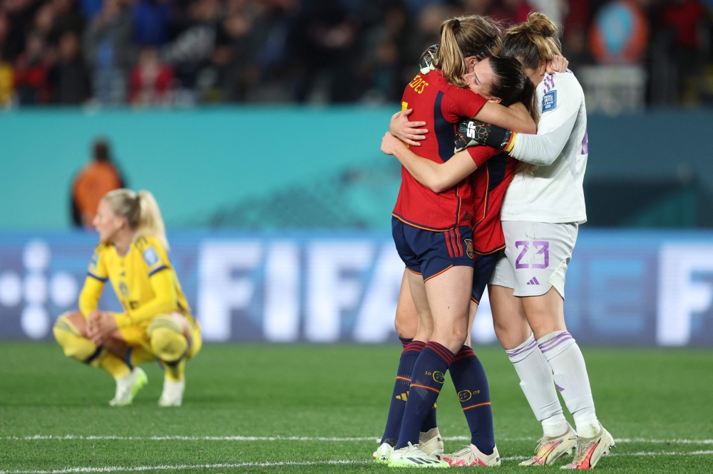 Spain players celebrate their victory after the end of the Australia and New Zealand 2023 Women's World Cup semi-final football match between Spain and Sweden at Eden Park in Auckland on August 15, 2023. (Photo by Michael Bradley / AFP)