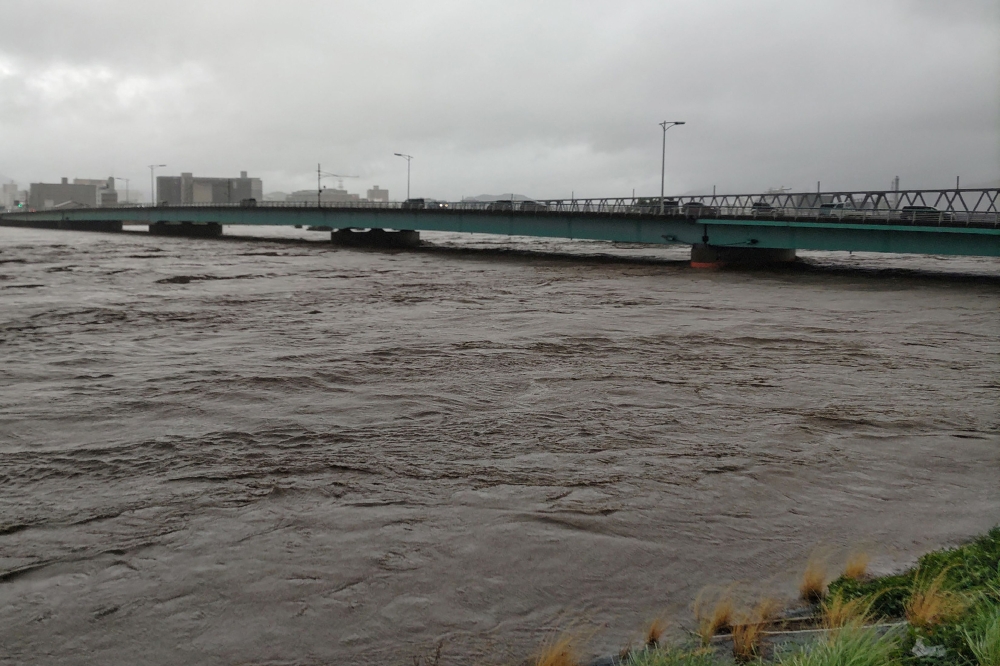 The Sendai River swollen due to heavy rains is pictured in the city of Tottori, Tottori prefecture on August 15, 2023. (Photo by Jiji Press / AFP) 