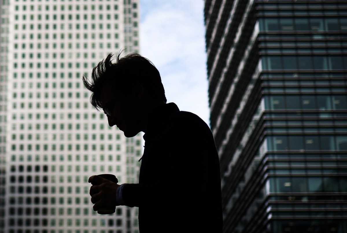 A pedestrian carries a coffee cup in London's central business district of Canary Wharf, on August 14, 2023. Photo by HENRY NICHOLLS / AFP