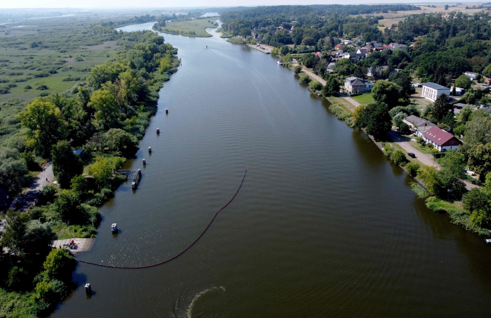 (Files) An aereal view shows Polish firefighters setting up a floating damm to catch dead fish from the river Oder, on August 16, 2022, in Gryfino near Szczecin, Poland. (Photo by Marcin Bielecki / AFP)