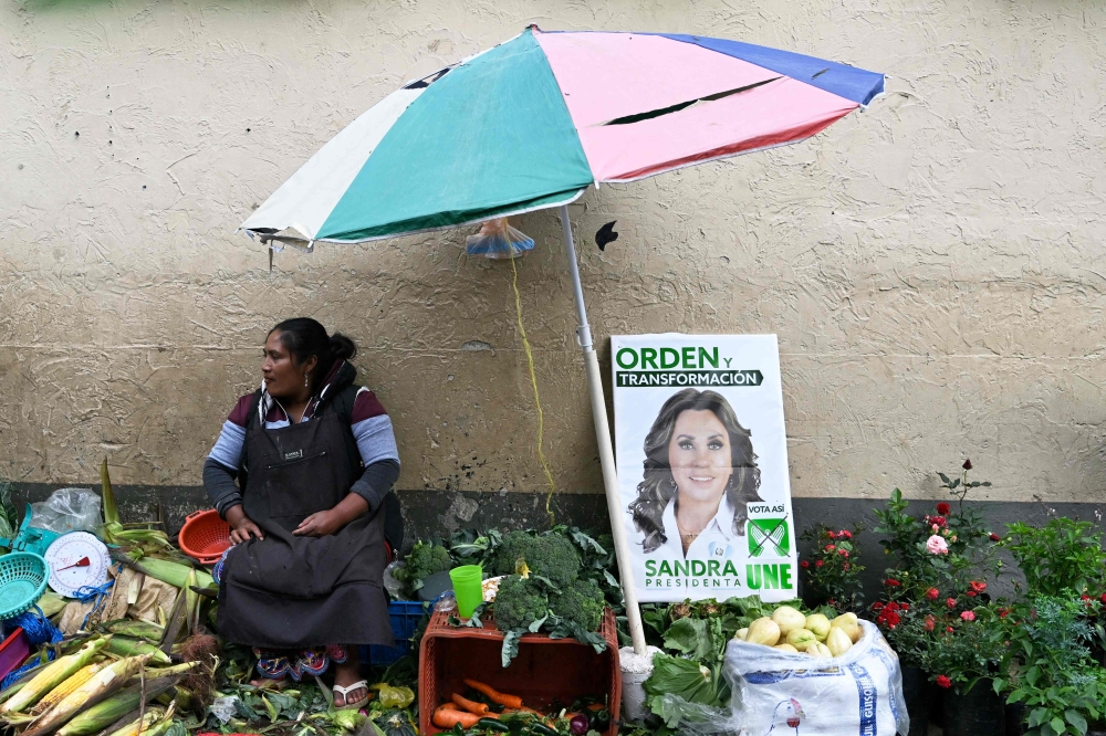 A street vendor displays a sign of Guatemalan candidate for the National Union of Hope party and former First Lady (2008–2011), Sandra Torres, before the closing of her campaign at the Terminal Market in Guatemala City, on August 18, 2023. (Photo by LUIS ACOSTA / AFP)
