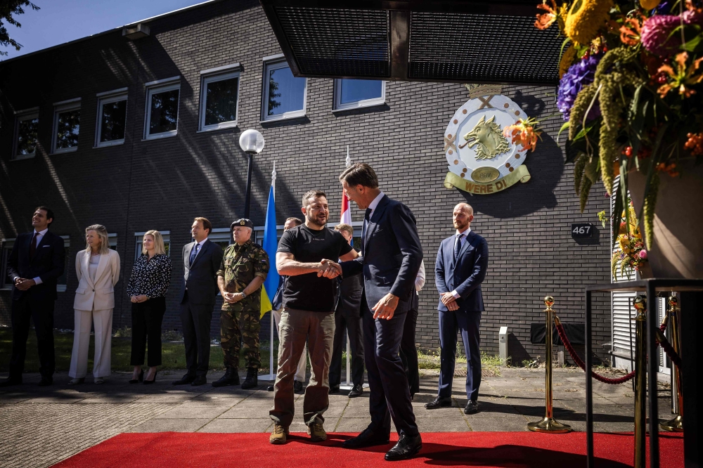 Ukrainian President Volodymyr Zelensky (L) and outgoing Dutch Prime Minister Mark Rutte shake hands during a visit... on August 20, 2023. (Photo by Rob Engelaar / ANP / AFP) 