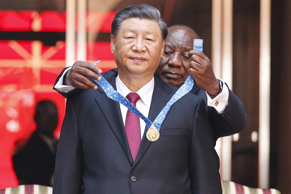 South African President Cyril Ramaphosa bestows the Order of South Africa to President of China Xi Jinping during Jinping's state visit at the Union Buildings in Pretoria on August 22, 2023. (Photo by Phill Magakoe / AFP)