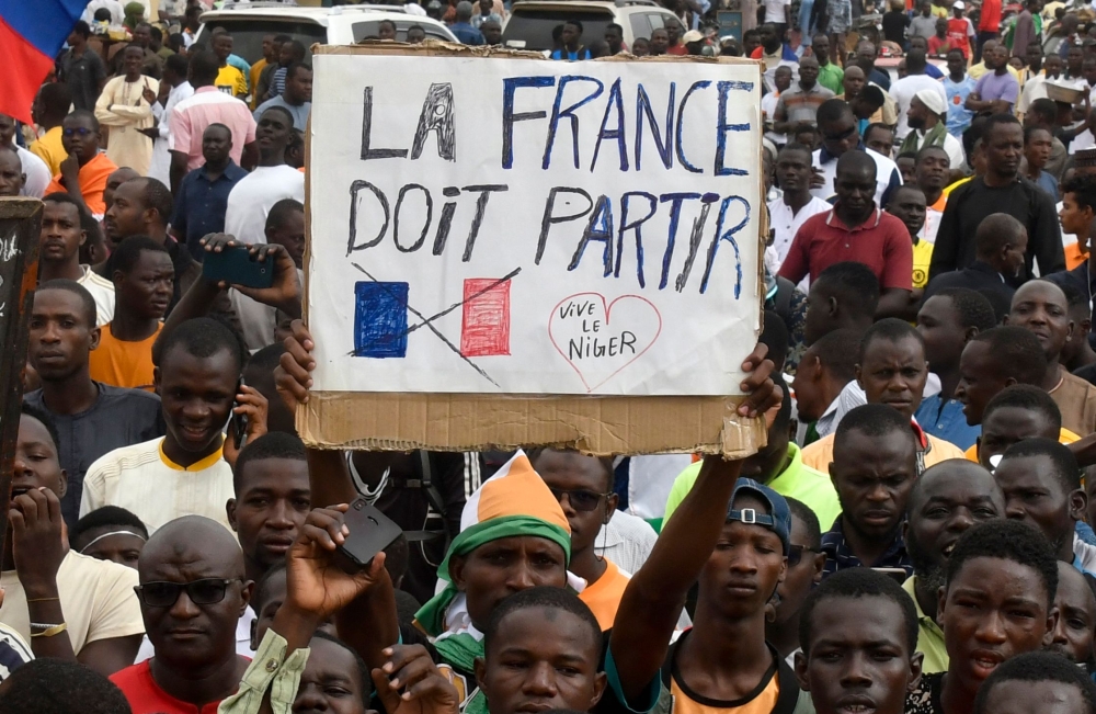 Protesters hold an anti-France placard during a demonstration on independence day in Niamey on August 3, 2023. (Photo by AFP) / ALTERNATE CROP

