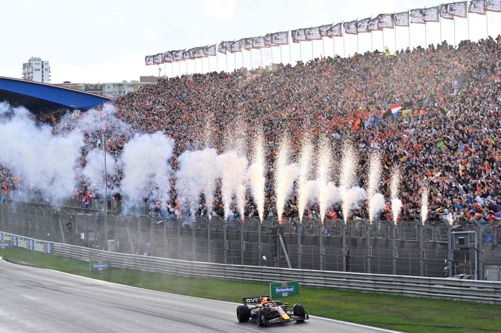 Pyrotechnics go off as Red Bull Racing's Dutch driver Max Verstappen crosses the finish line to win the Dutch Formula One Grand Prix race at The Circuit Zandvoort, in Zandvoort on August 27, 2023. (Photo by JOHN THYS / AFP)