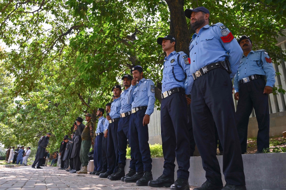 Policemen stand guard outside the Islamabad High Court building in Islamabad on August 29, 2023, during the hearing of Imran Khan's plea seeking suspension of a three-year jail term. (Photo by Farooq Naeem / AFP)