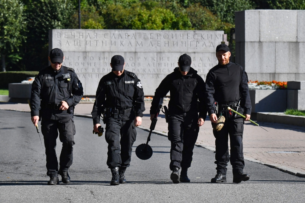 Russian police sappers walk at the Serafimovskoye cemetery in Saint Petersburg on August 29, 2023. (Photo by Olga Maltseva / AFP)
