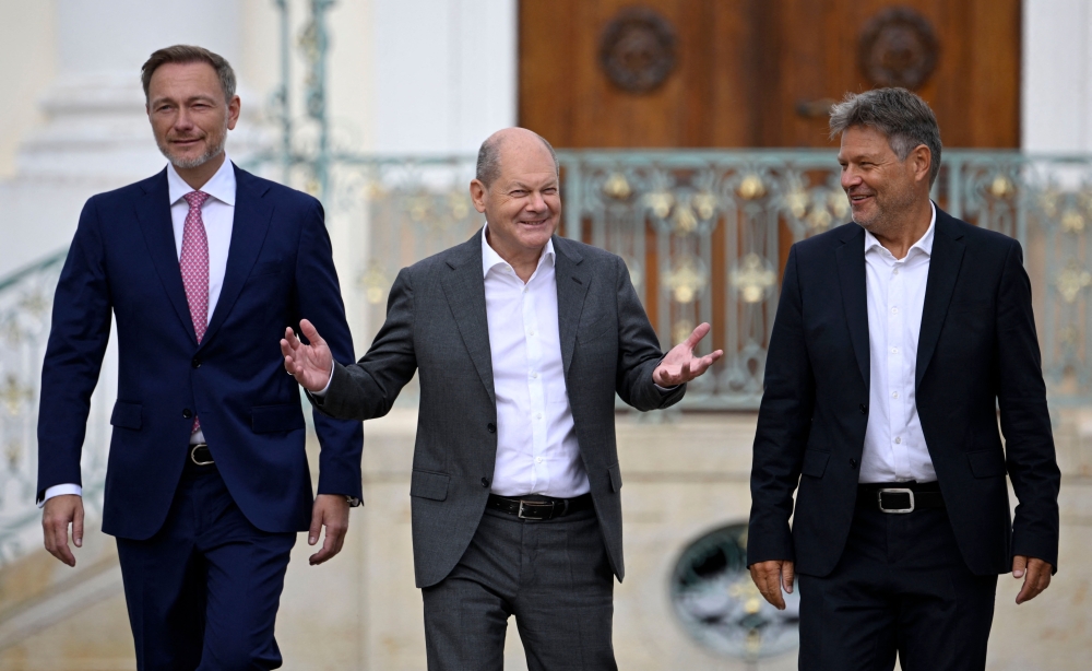 (L-R) German Finance Minister Christian Lindner, German Chancellor Olaf Scholz and German Minister of Economics and Climate Protection Robert Habeck arrive to address a press conference after the second day of a retreat meeting of the German cabinet at Meseberg Palace on August 30, 2023 in Meseberg, north of Berlin, eastern Germany. (Photo by Tobias SCHWARZ / AFP)