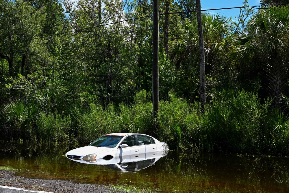 A car is seen downed on the side of a road in Crystal River, Florida on August 31, 2023, after Hurricane Idalia made landfall. Idalia barreled into the northwest Florida coast as a powerful Category 3 hurricane on Wednesday morning, the US National Hurricane Center said. (Photo by CHANDAN KHANNA / AFP)
