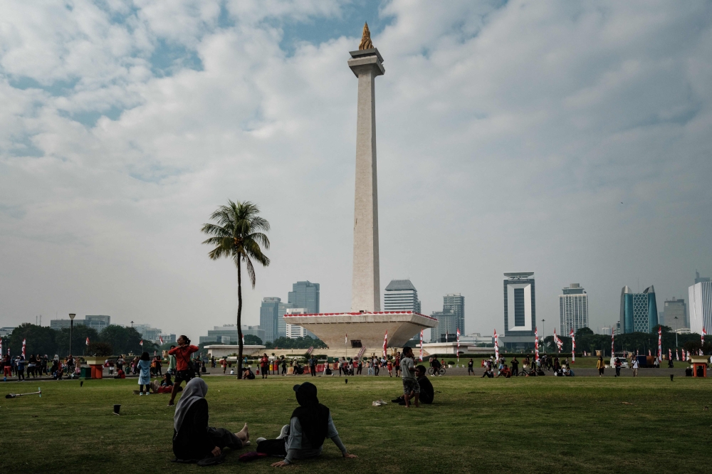 People gather in the park of the National Monument (Monas) in Jakarta on August 6, 2023. Photo by Yasuyoshi CHIBA / AFP

