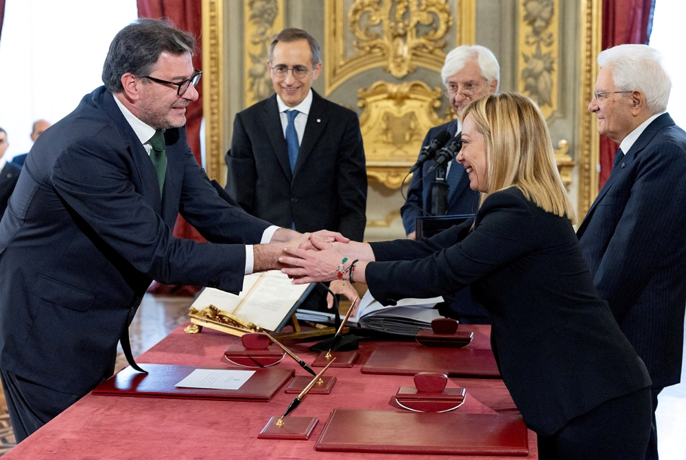 File photo: Italy's new Economy Minister Giancarlo Giorgetti shakes hands with Italy's Prime Minister Giorgia Meloni during the swearing-in ceremony at the Quirinale Presidential Palace, in Rome, Italy, October 22, 2022. (Italian Presidency/Handout via REUTERS)

