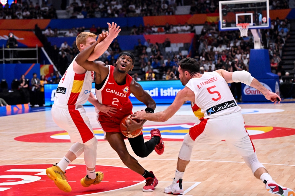 Spain's Alberto Diaz (left) and Rudy Fernandez (right) block Canada's Shai Gilgeous-Alexander during the FIBA Basketball World Cup match between Spain and Canada at Indonesia Arena in Jakarta on September 3, 2023. (Photo by Adek Berry / AFP)